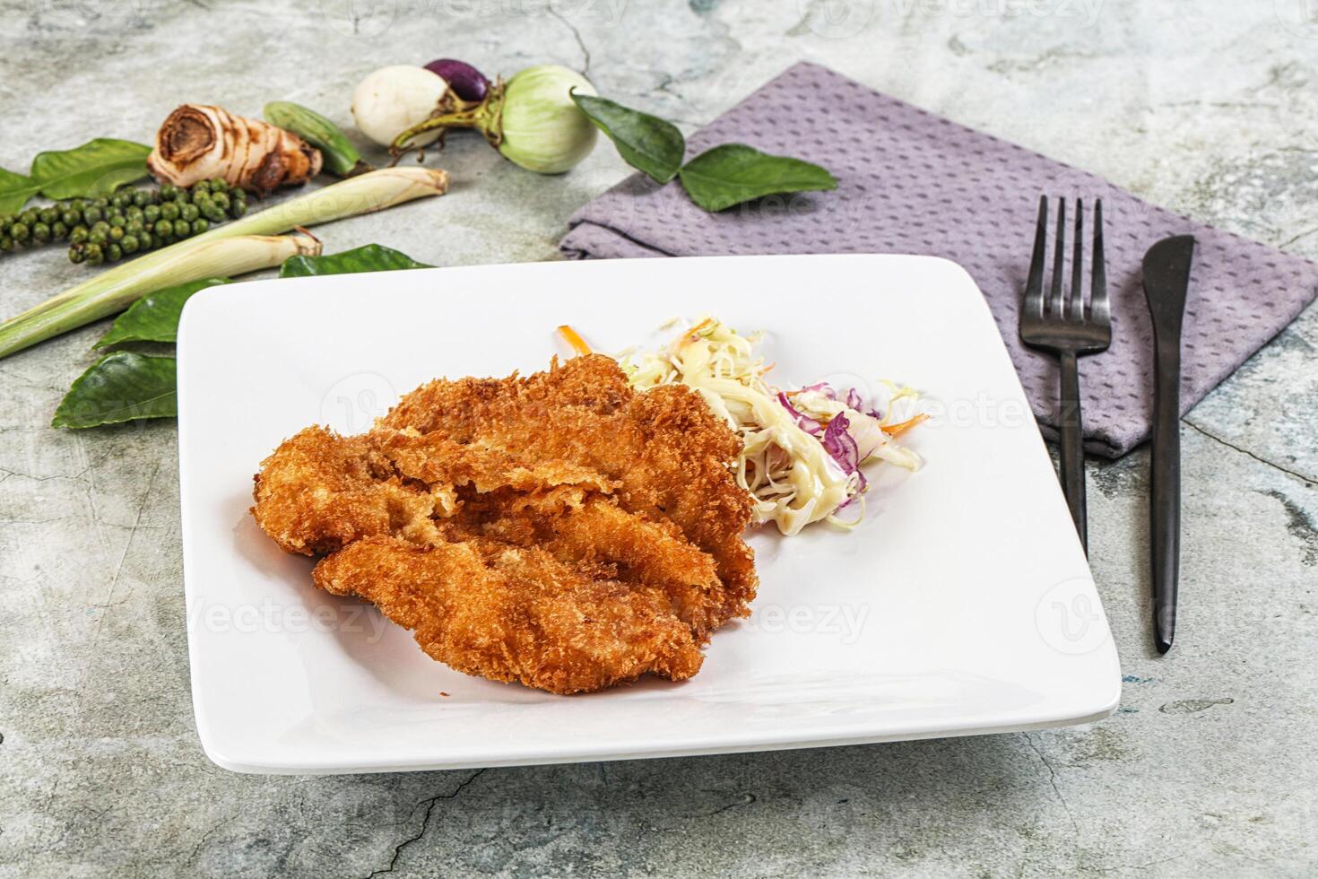 Fried chicken cutlets on a white plate with vegetables photo