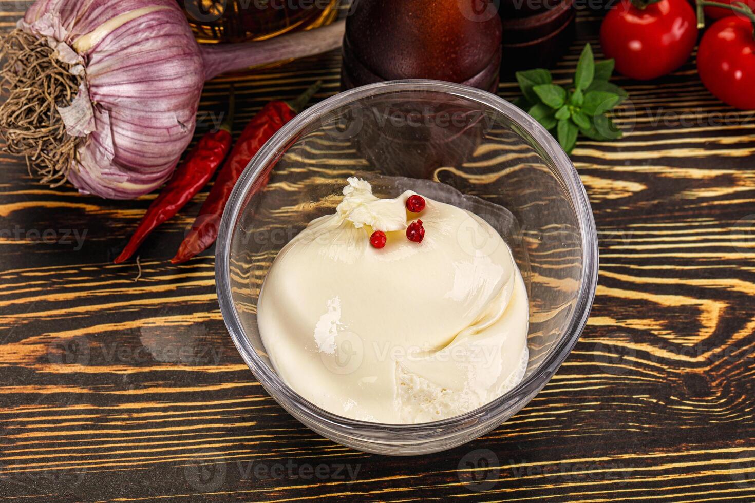 A bowl of ice cream sitting on a table next to other ingredients photo