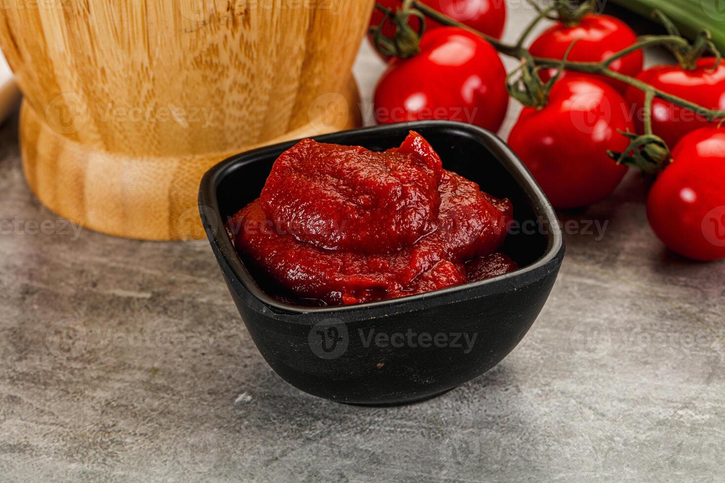 A bowl of tomato sauce next to a knife and a knife photo