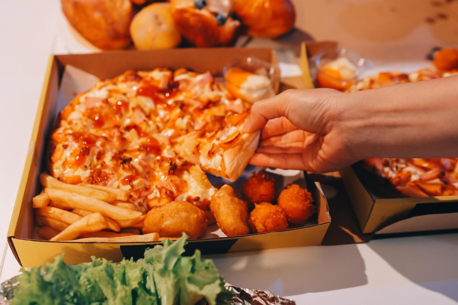 A person taking a piece of pizza out of a box photo