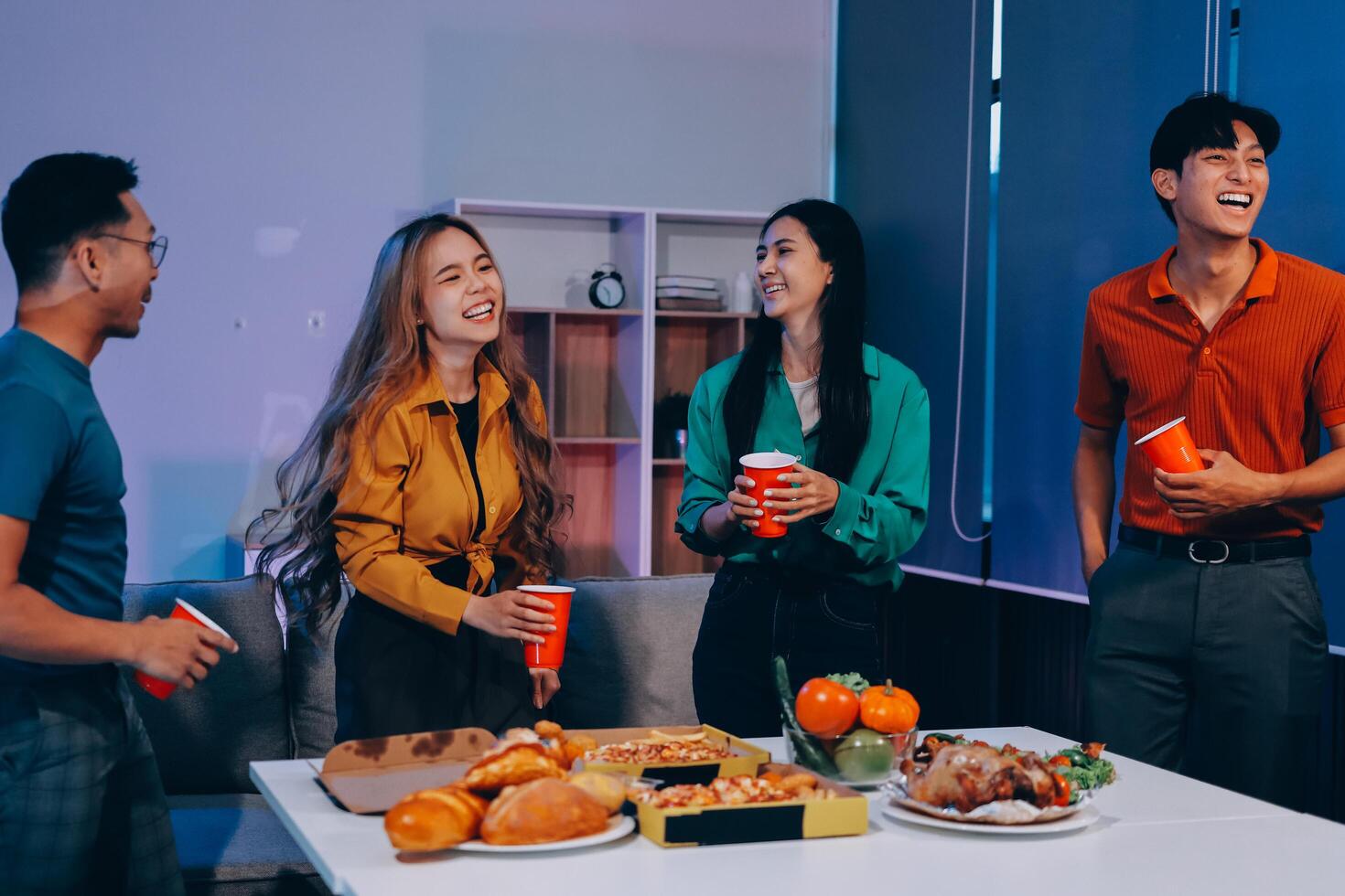 Four friends having a party with food and drinks photo