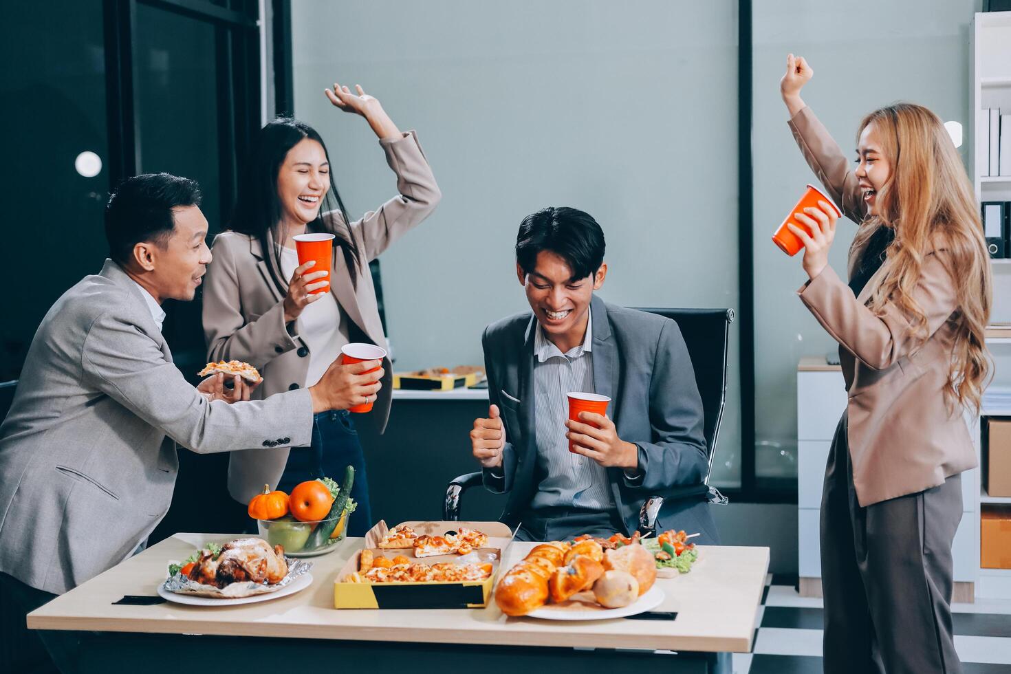 Business people enjoying food and drinks at an office photo