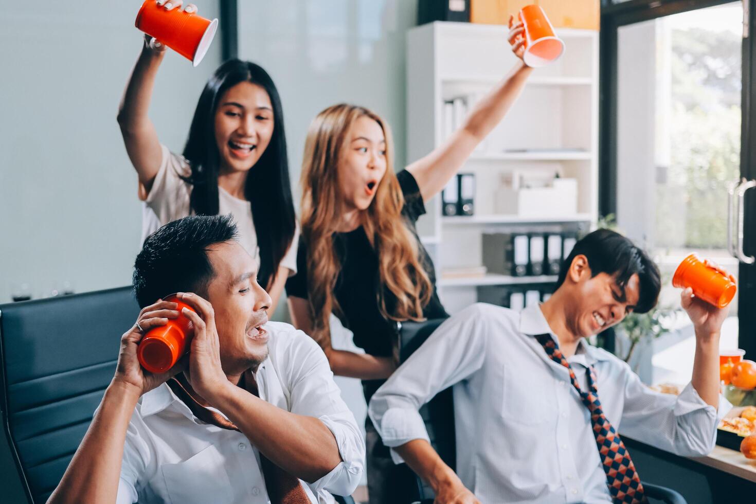 Group of young asian business people celebrating in office photo