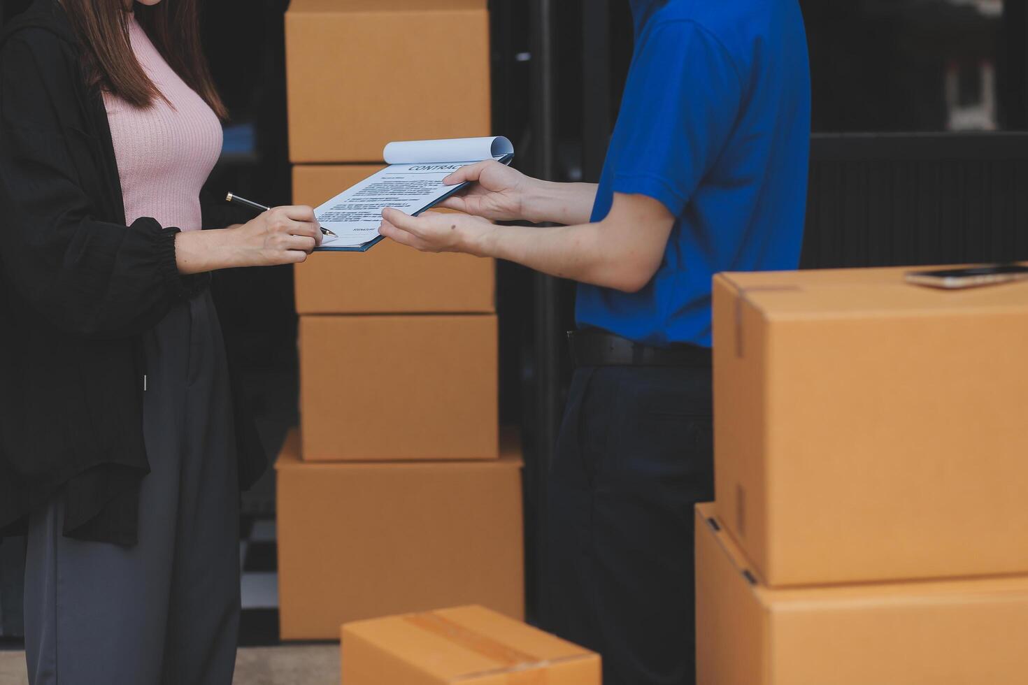 A man and woman are standing in front of a moving van photo