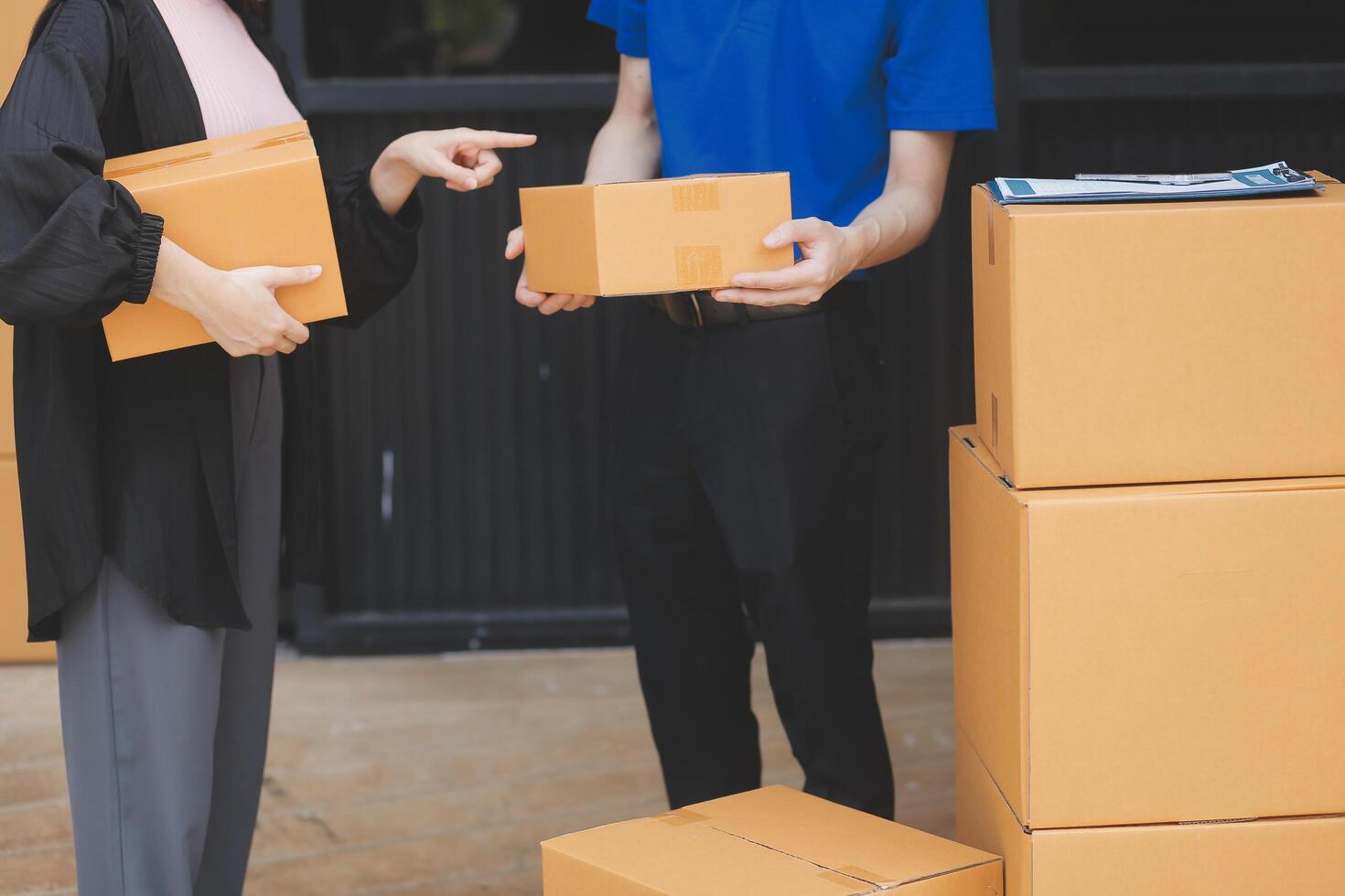 A man and woman are holding boxes and looking at each other photo