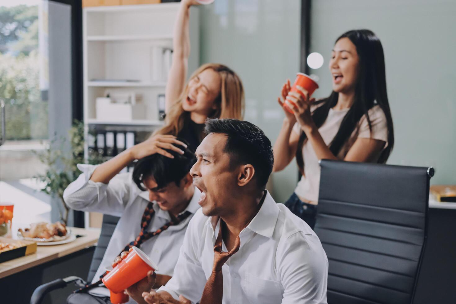 Group of people in an office with one person holding a cup photo