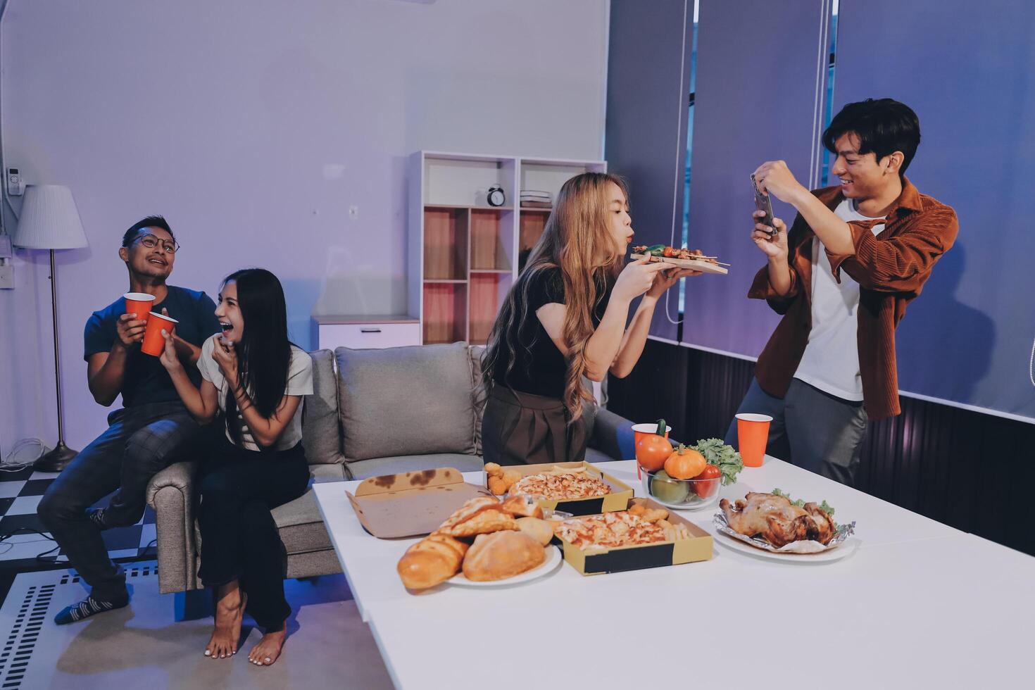 A group of people sitting around a table with food photo