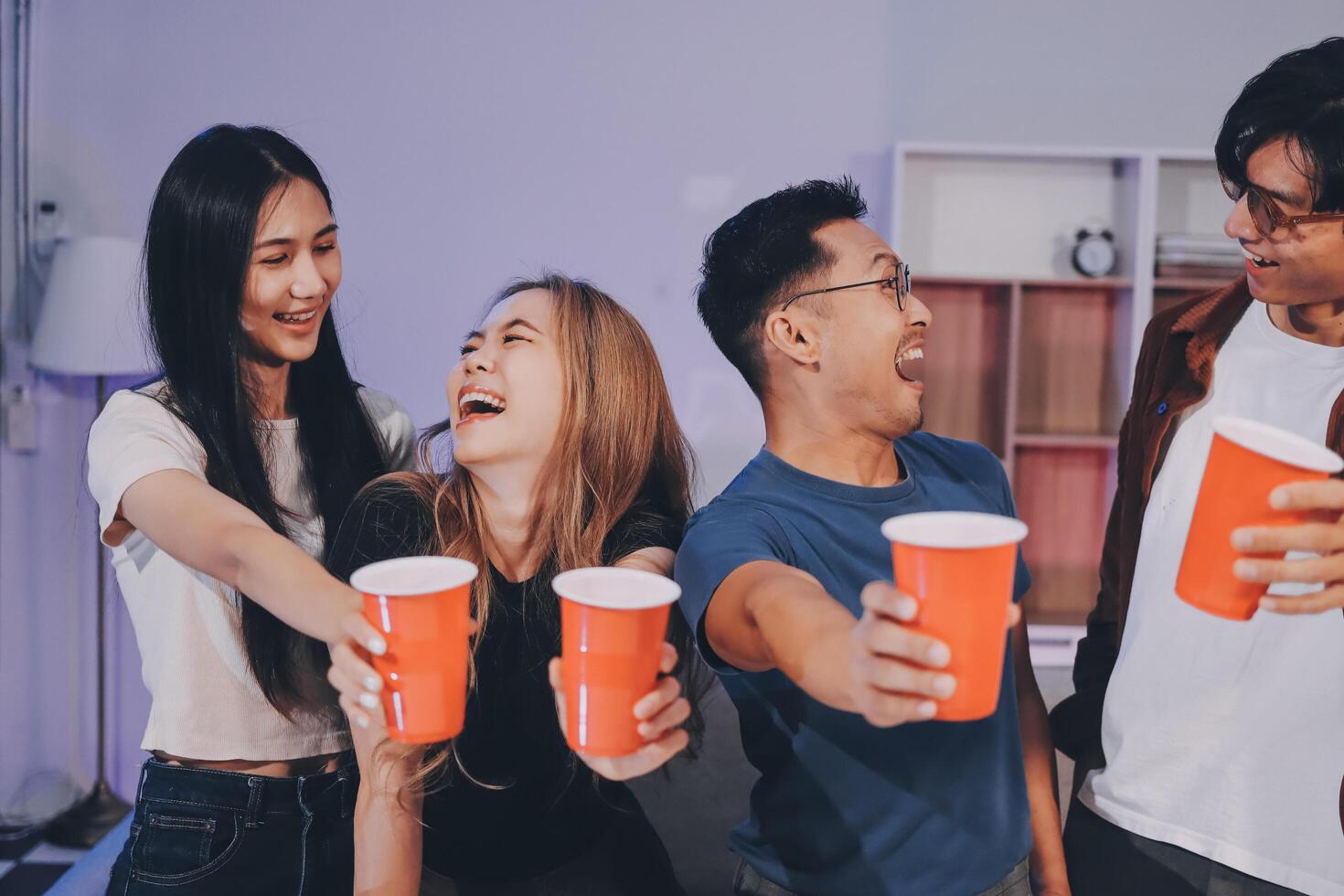 Four friends holding red cups and laughing photo