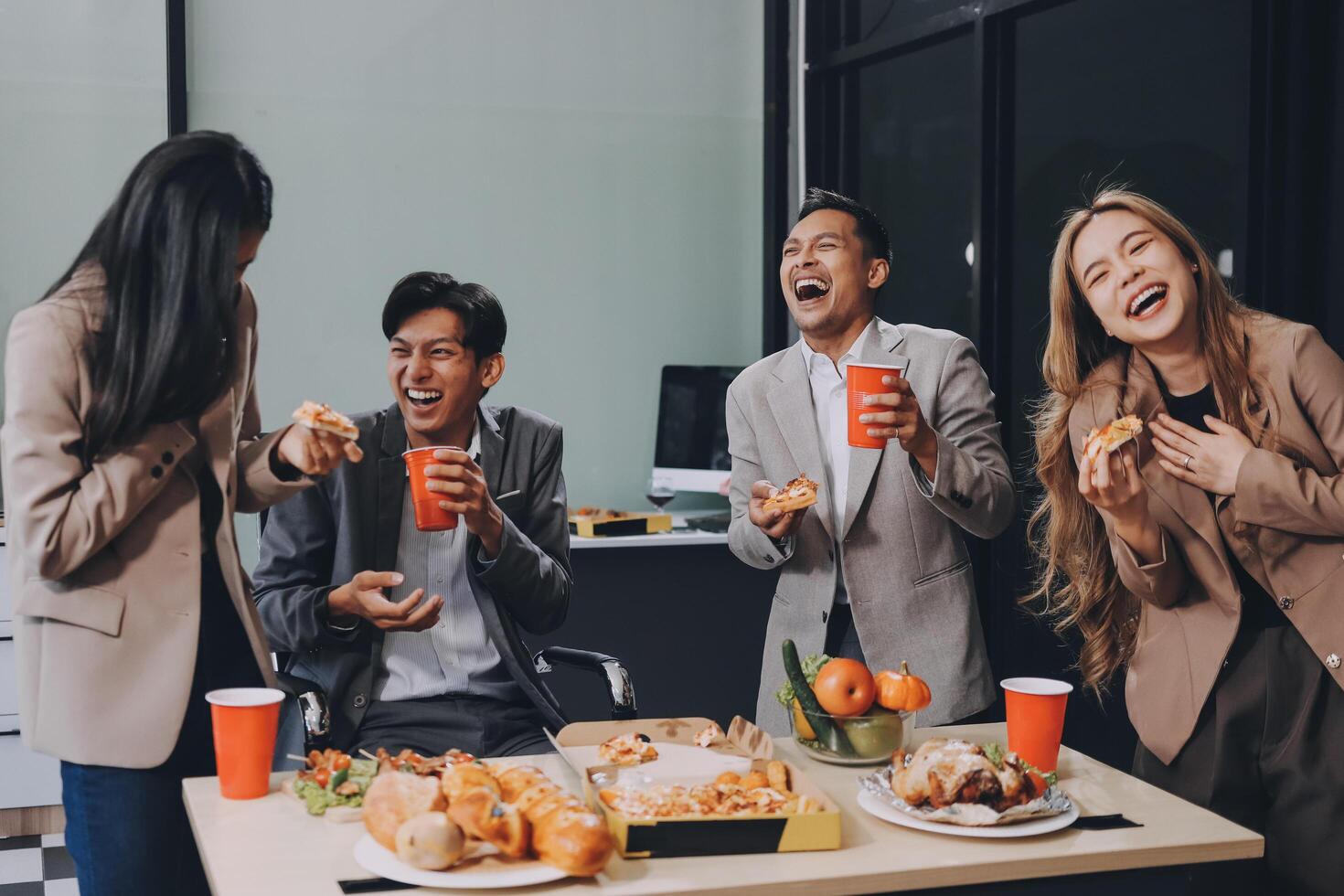 Four people eating food and laughing at a table photo