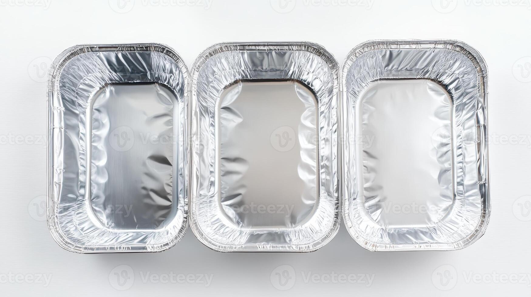 Aluminum foil trays arranged in a row on a clean surface for food preparation or storage purposes in a kitchen environment photo