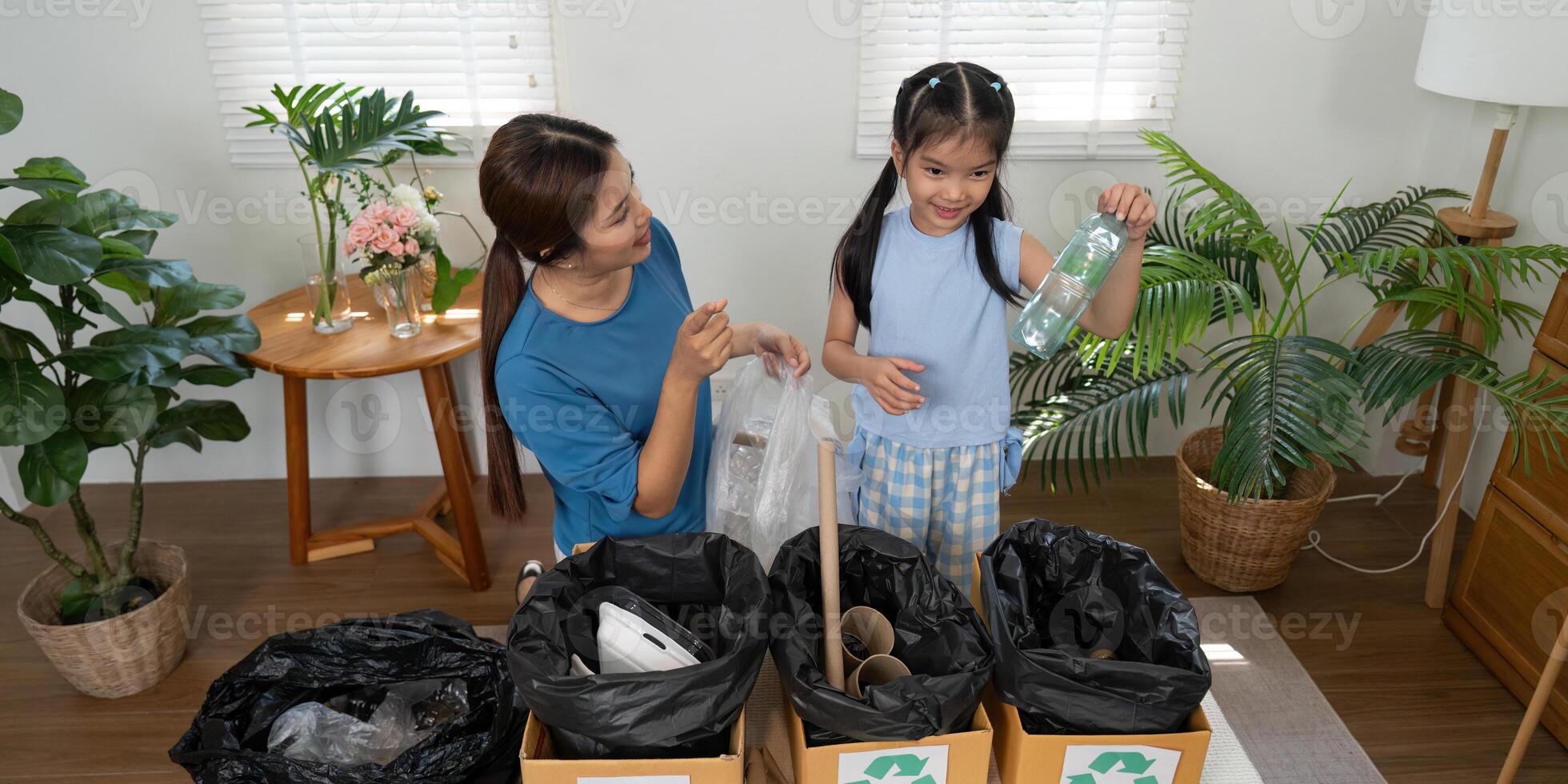 Sustainability and Family Bonding. A mother and daughter practicing recycling at home with enthusiasm. photo