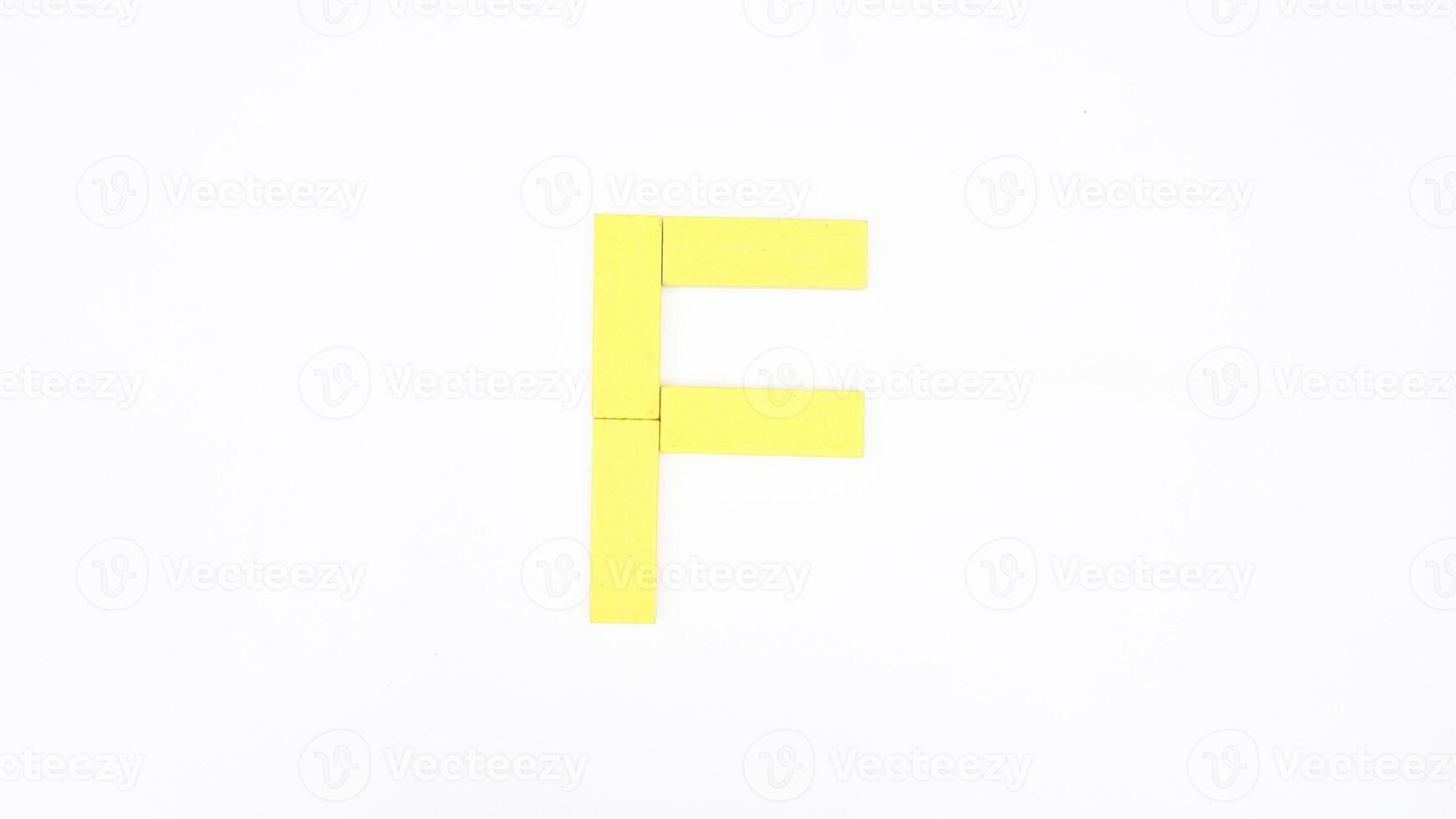 Letter F from yellow color wood block isolated on white background photo
