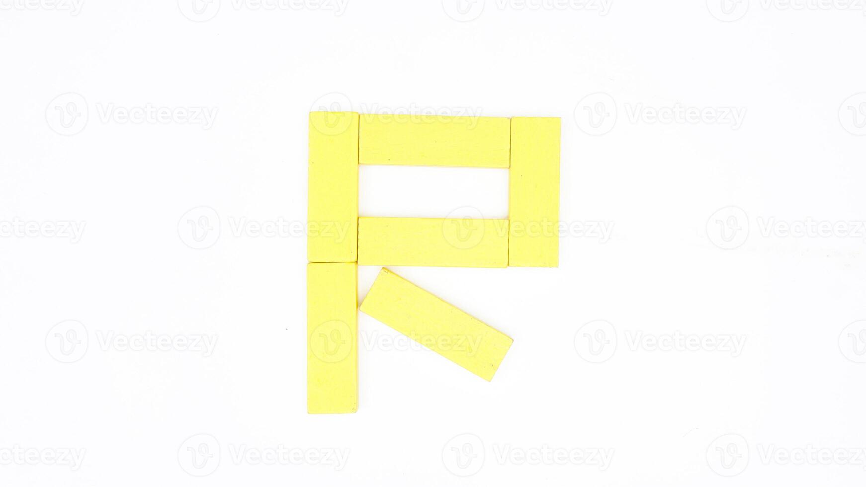 Isolated letter R from yellow color wood block on white background photo