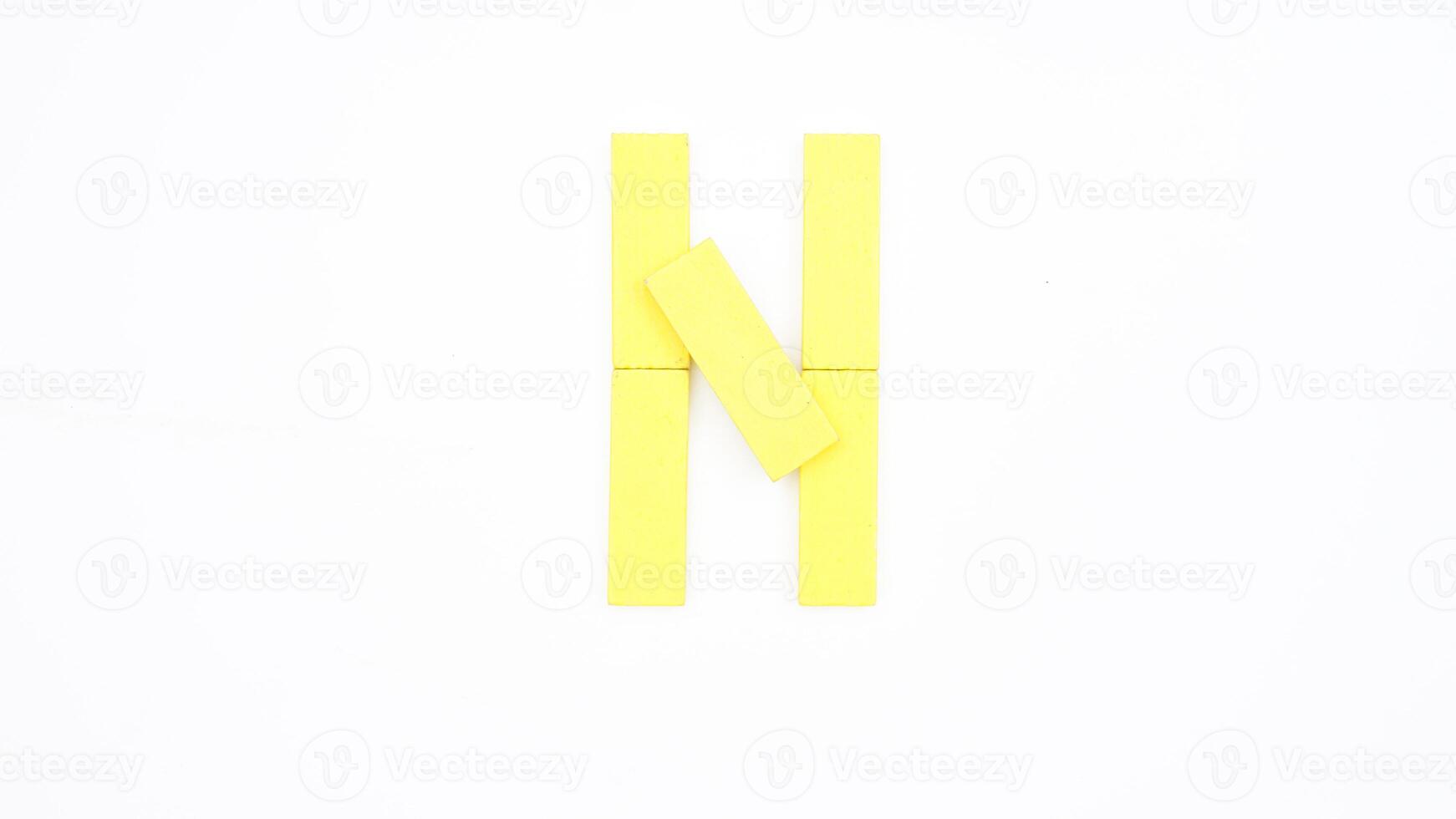 Letter N from yellow color wood block isolated on white background photo