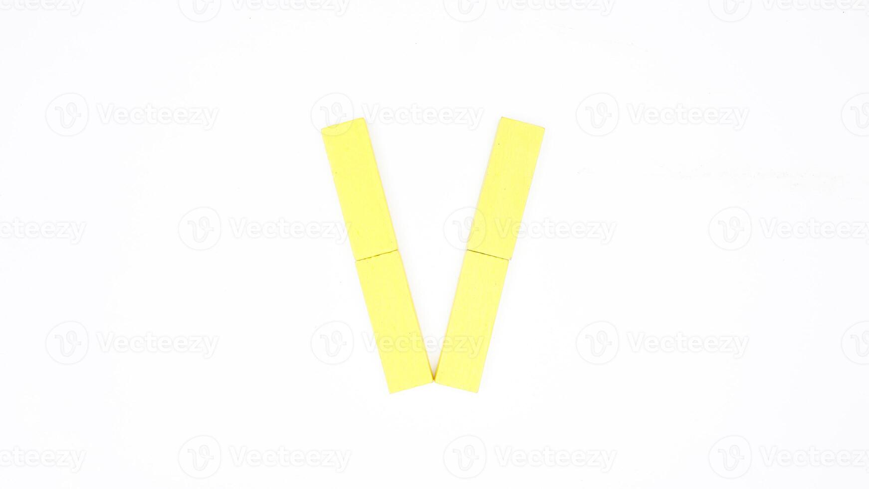 Letter V from yellow color wood block isolated on white background photo