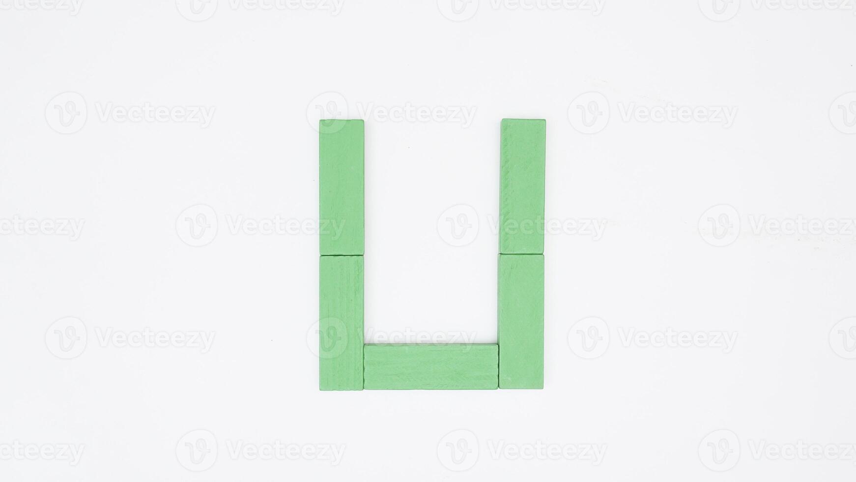 Letter U from green color wood block isolated on white background photo