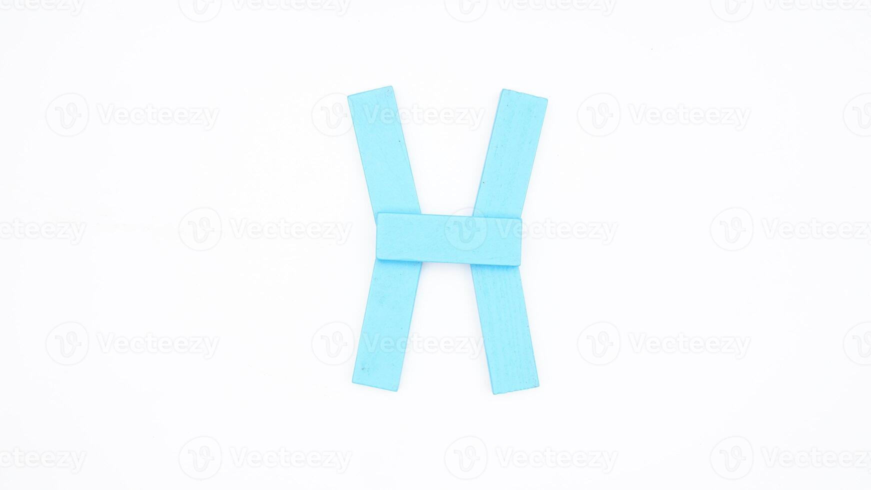 Isolated letter H from blue color wood block on white background photo