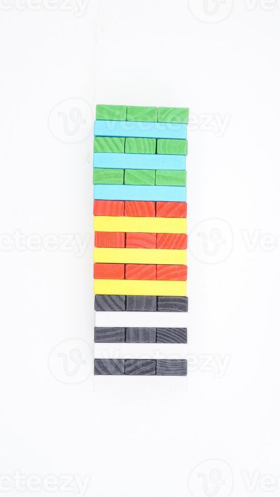 Board game tower made of wooden blocks isolated on white background photo