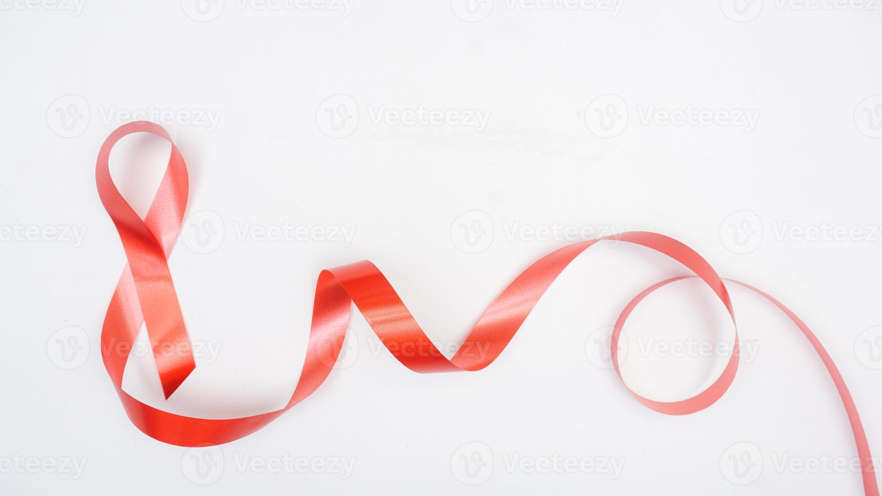 Close up of red ribbon with curly isolated on white background photo