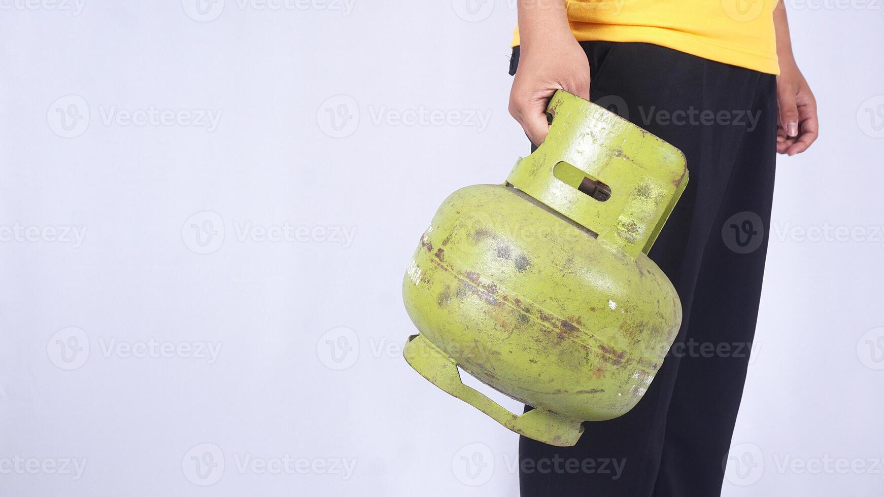 Asian man holding Indonesia 3kg green LPG gas cylinder isolated on white background photo
