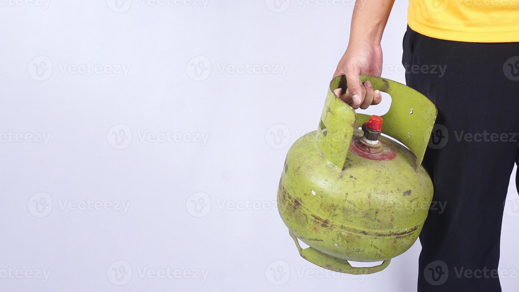 Asian man holding Indonesia 3kg LPG gas cylinder isolated on white background photo