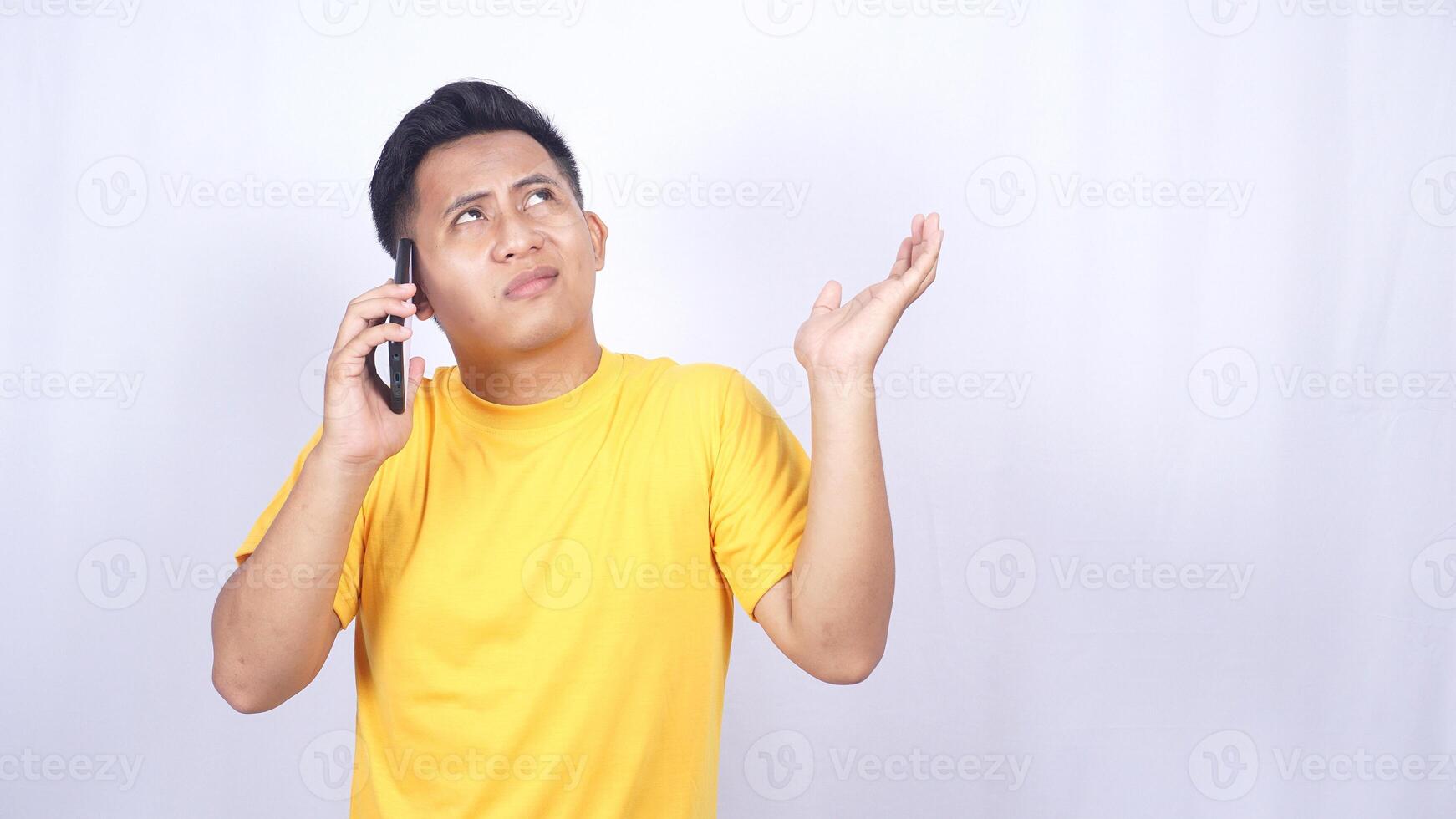 Confused Asian man while doing phone call isolated on white background photo