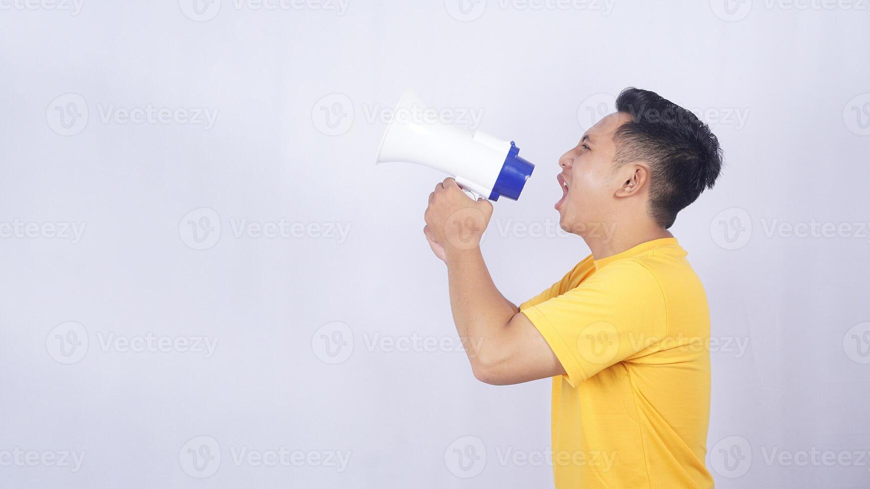 Side view of Young Asian man shouting on megaphone isolated on white background photo