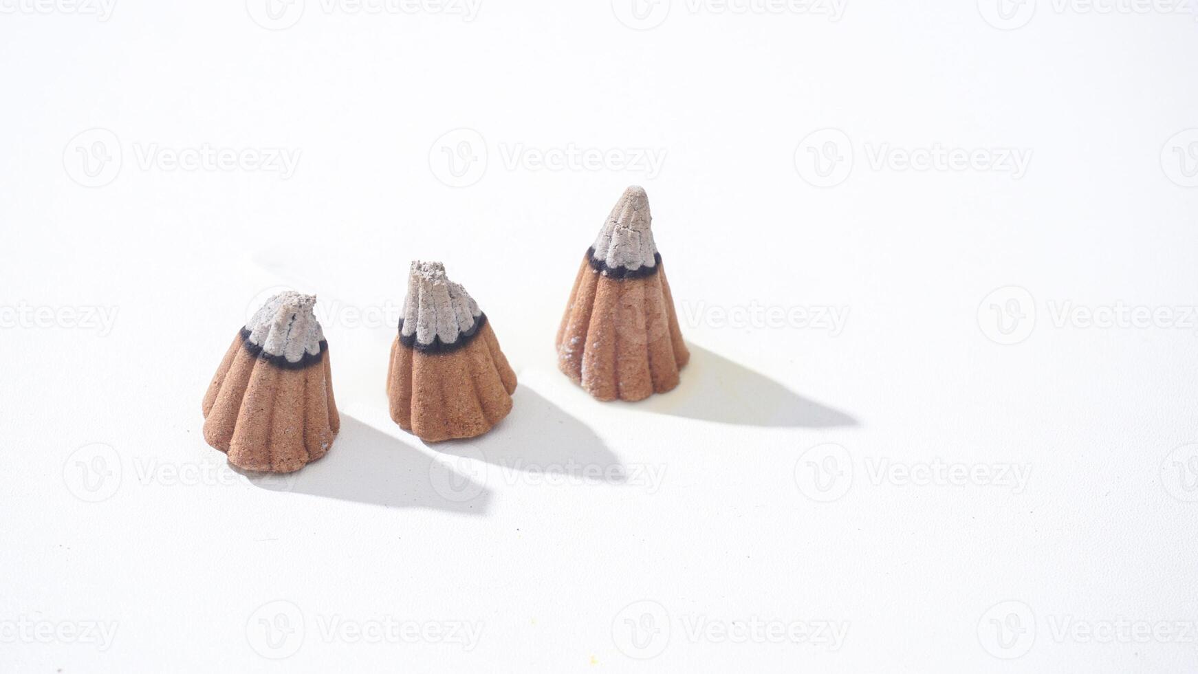 Three burned aroma incense cones for aromatherapy isolated white background photo