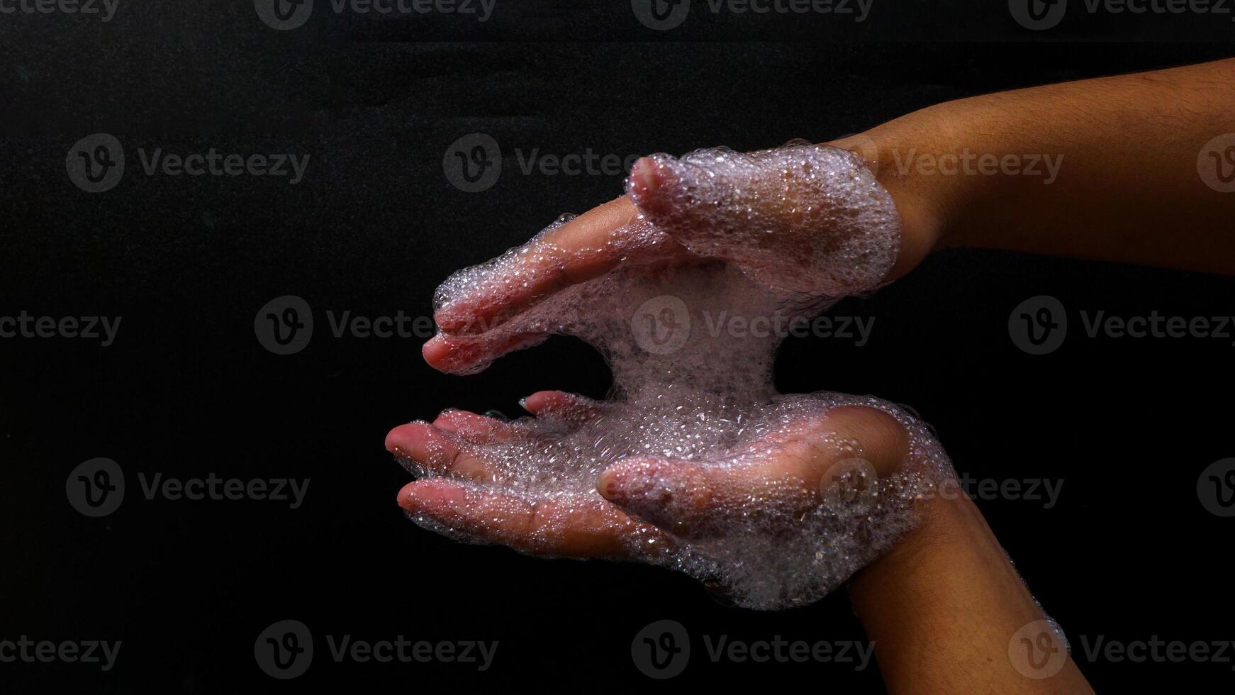 Hand with lots of bubble foam isolated on black background photo