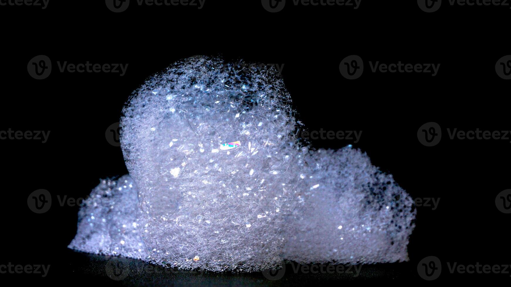 Close up of abstract white bubbles foam texture isolated on black background photo