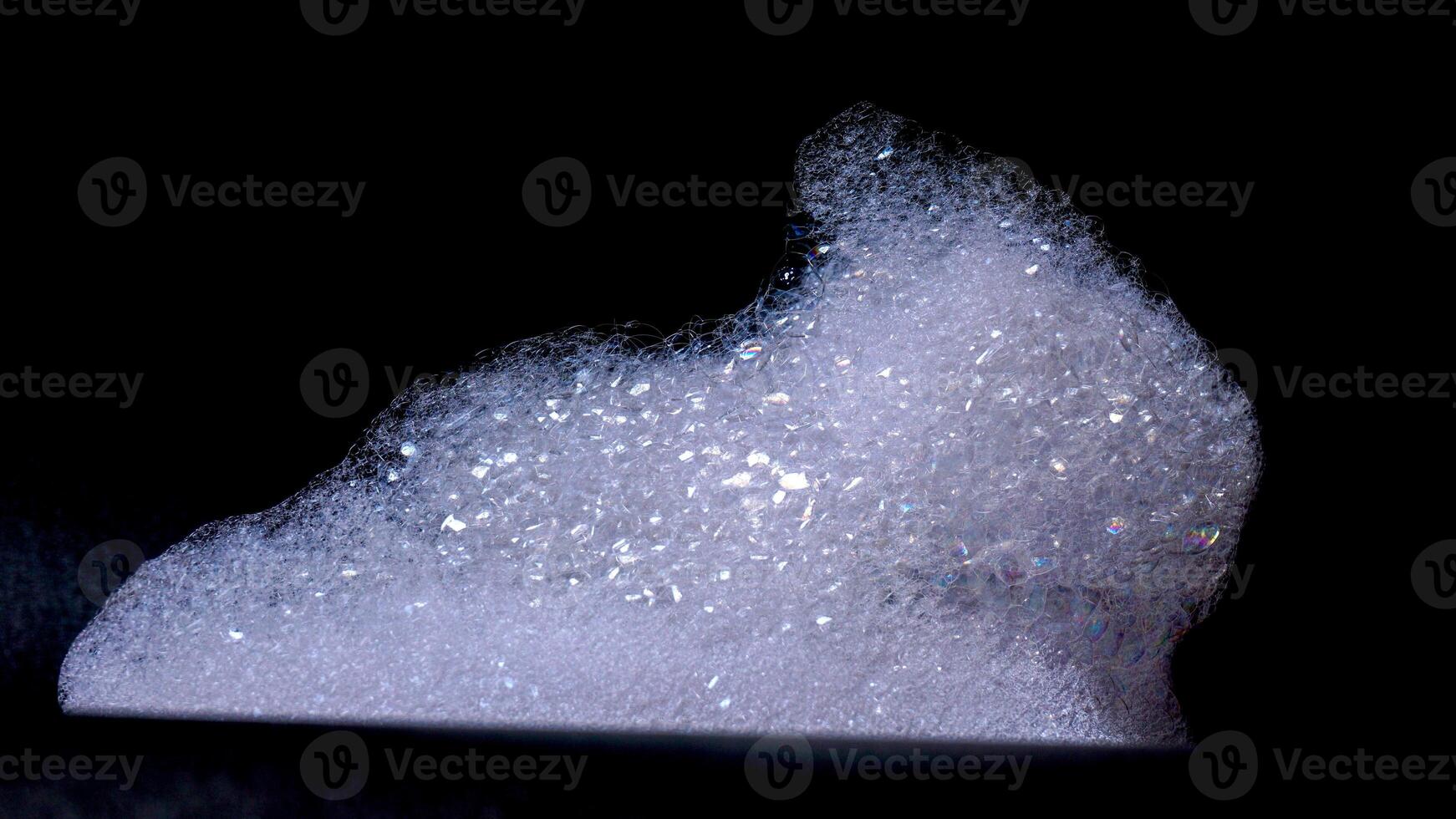 Close up of white bubbles foam isolated on black background photo