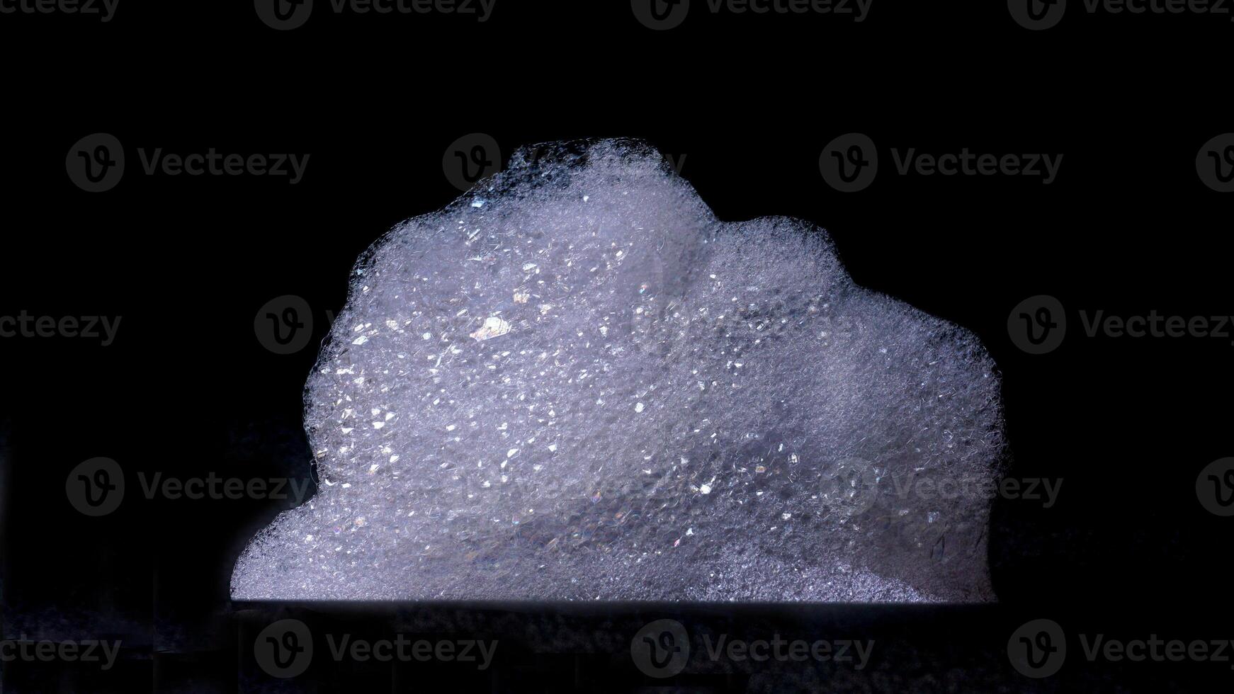 Close up of white bubbles foam texture isolated on black background photo