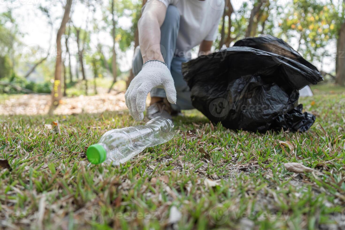 Close-up of a volunteer picking up plastic waste during a community cleanup event. photo