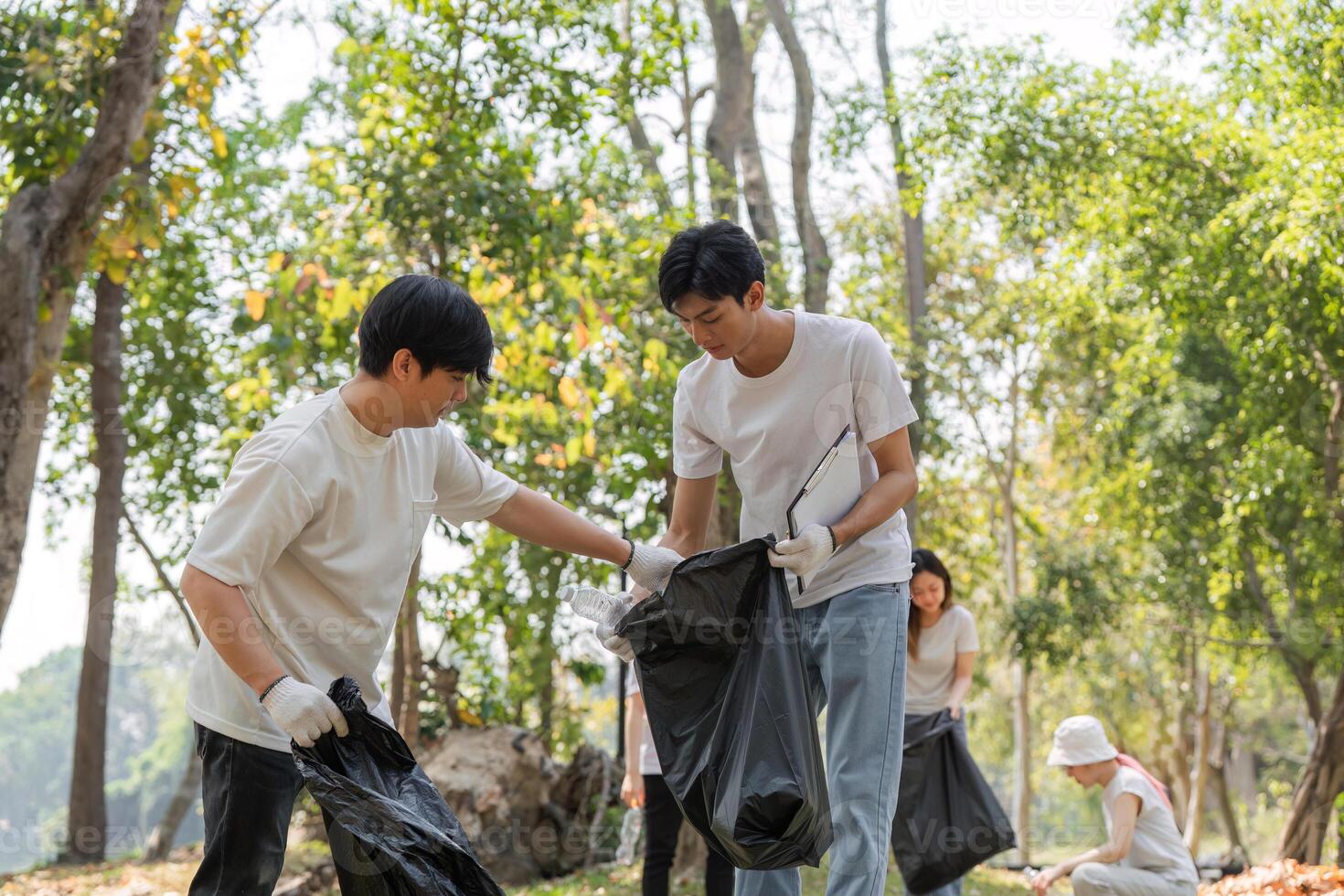 Volunteers participating in a community cleanup event in a park, promoting sustainability and environmental care. photo
