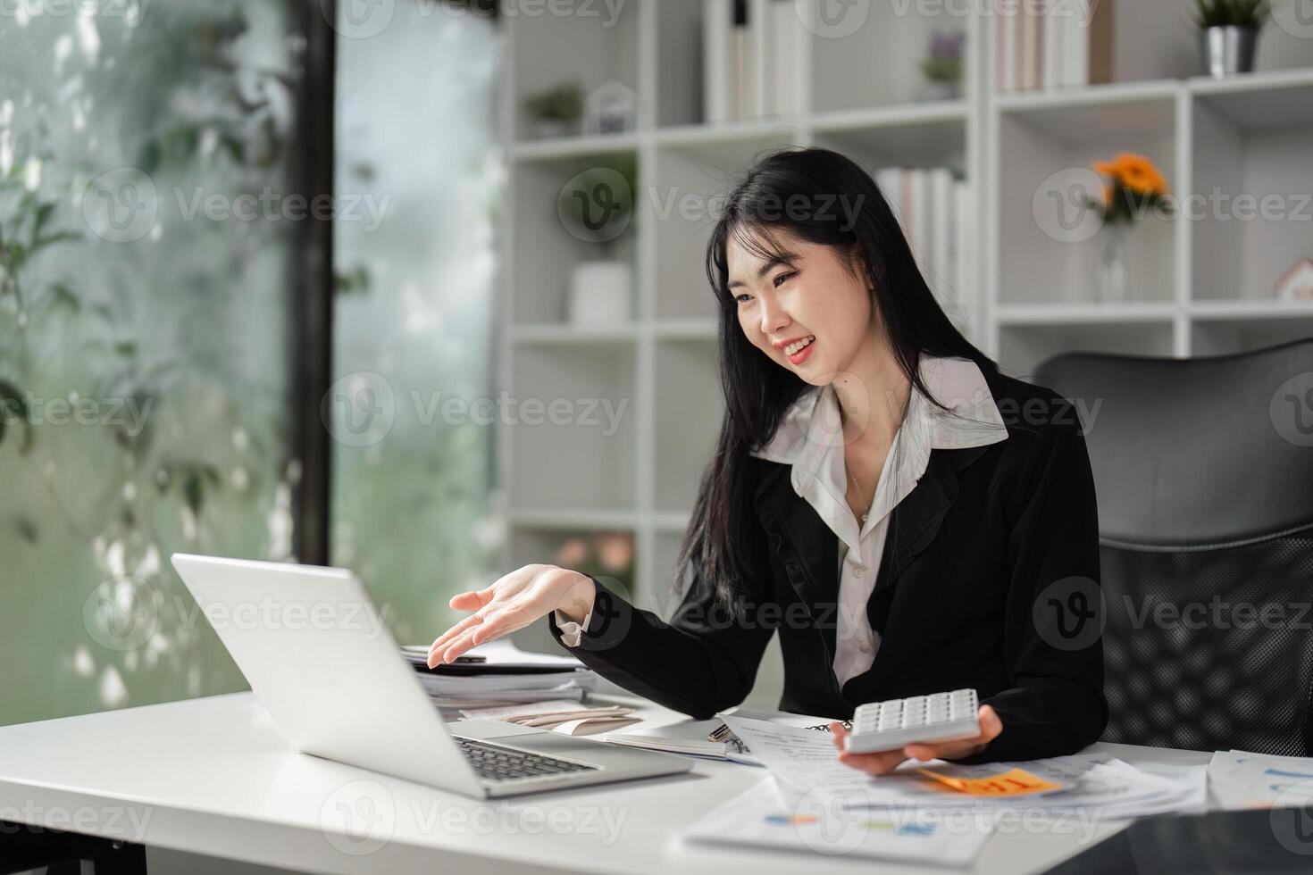 Cheerful businesswoman explaining financial concepts while working on a laptop. photo
