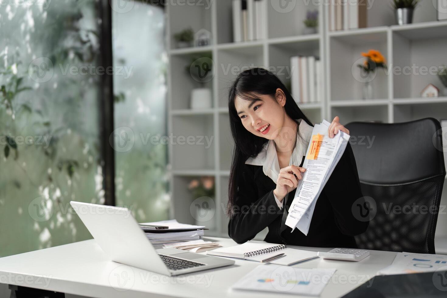 Businesswoman reviewing tax documents and filing reports in a modern office setting. photo