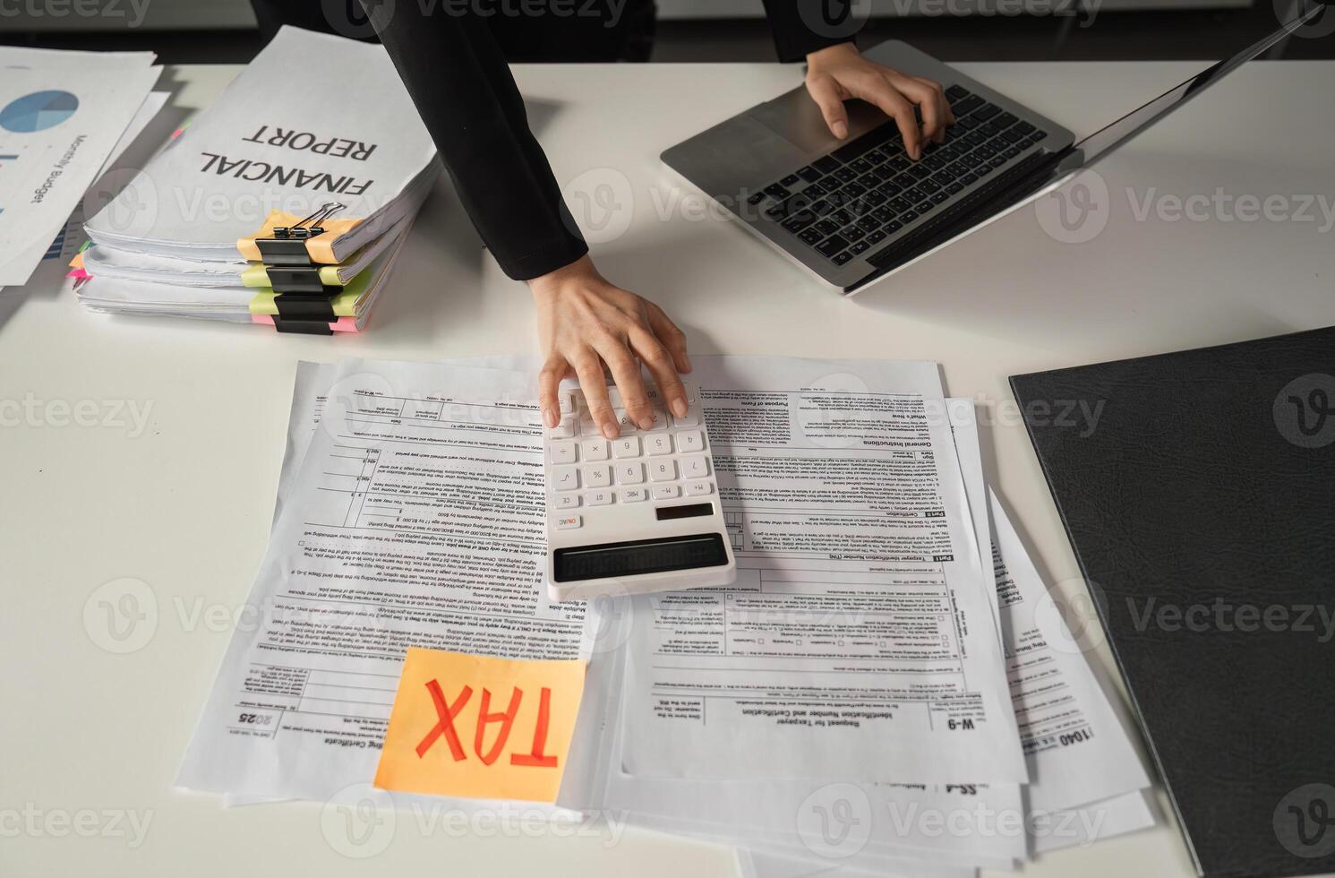 Businesswoman calculating finances using a calculator and managing tax paperwork. photo