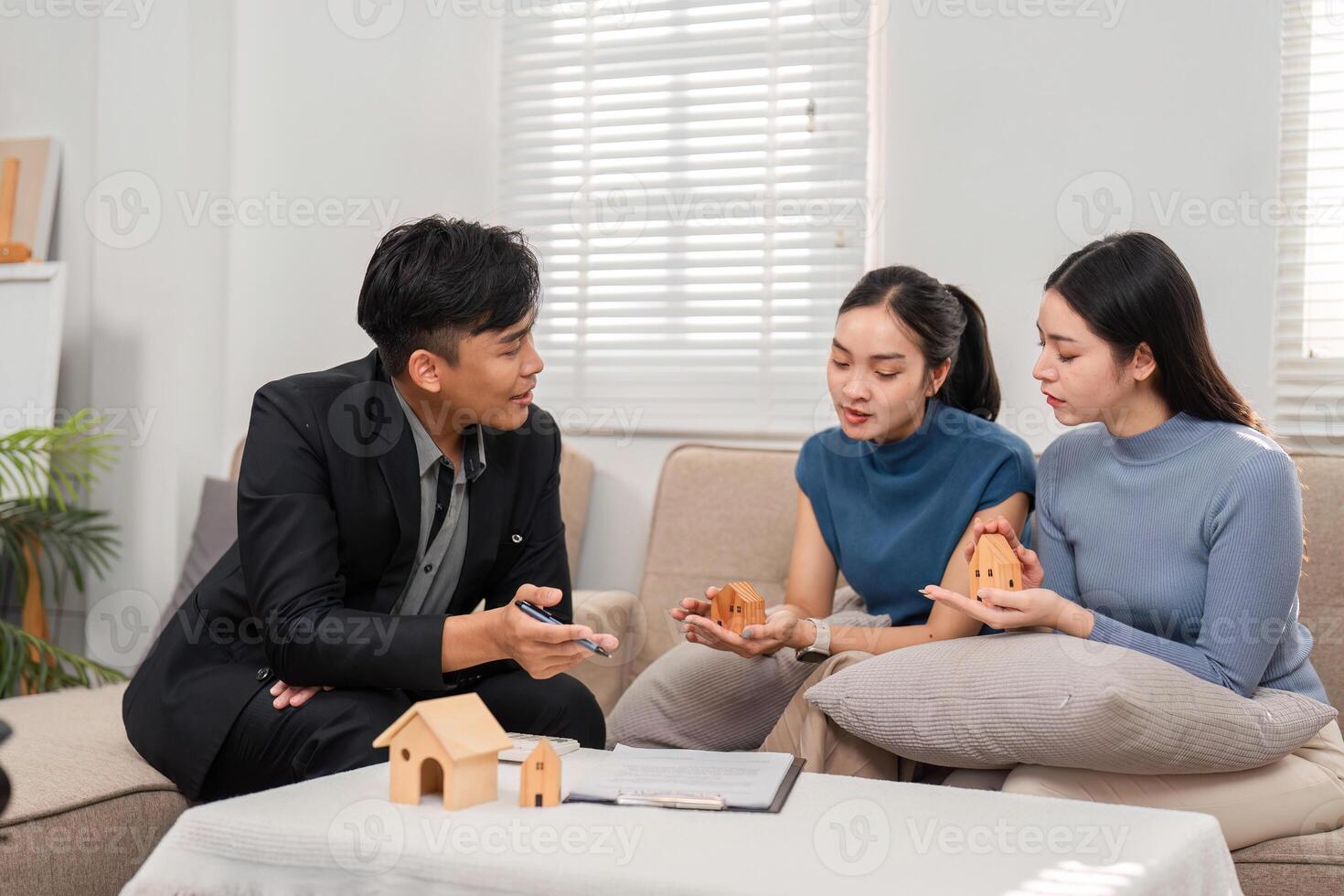 Real Estate Consultation. A smiling real estate agent discussing options with two women in a welcoming environment. photo