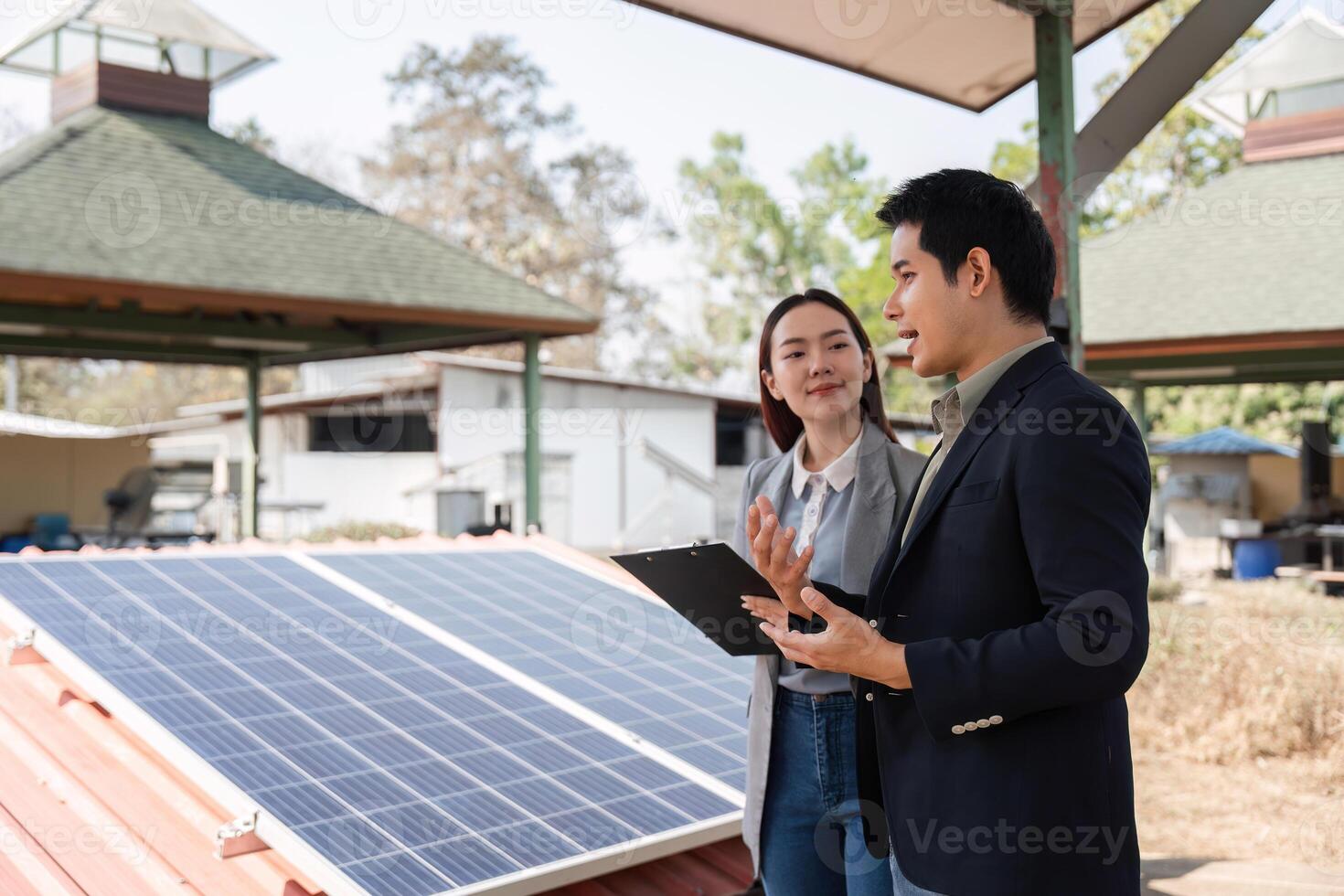 Sustainable business collaboration. Business professionals discussing renewable energy solutions by solar panels. photo