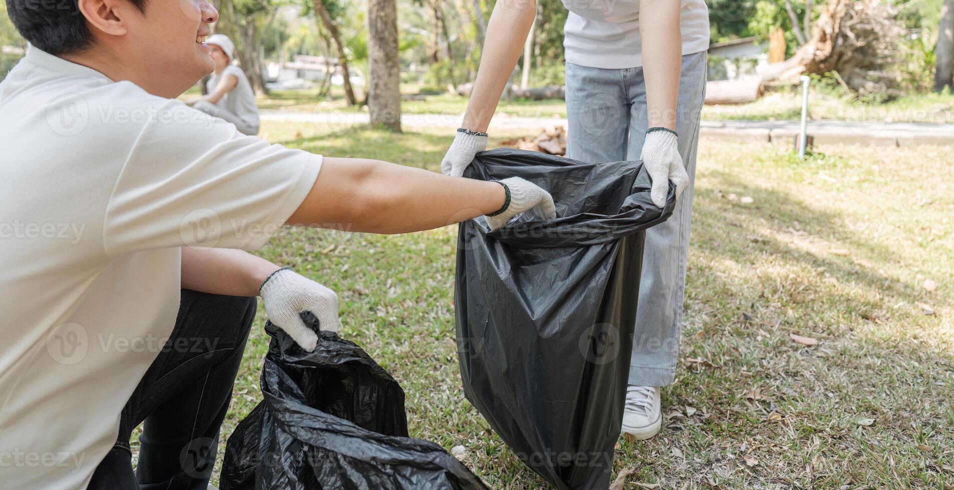 Volunteers sorting trash bags during a community cleanup, promoting environmental awareness. photo