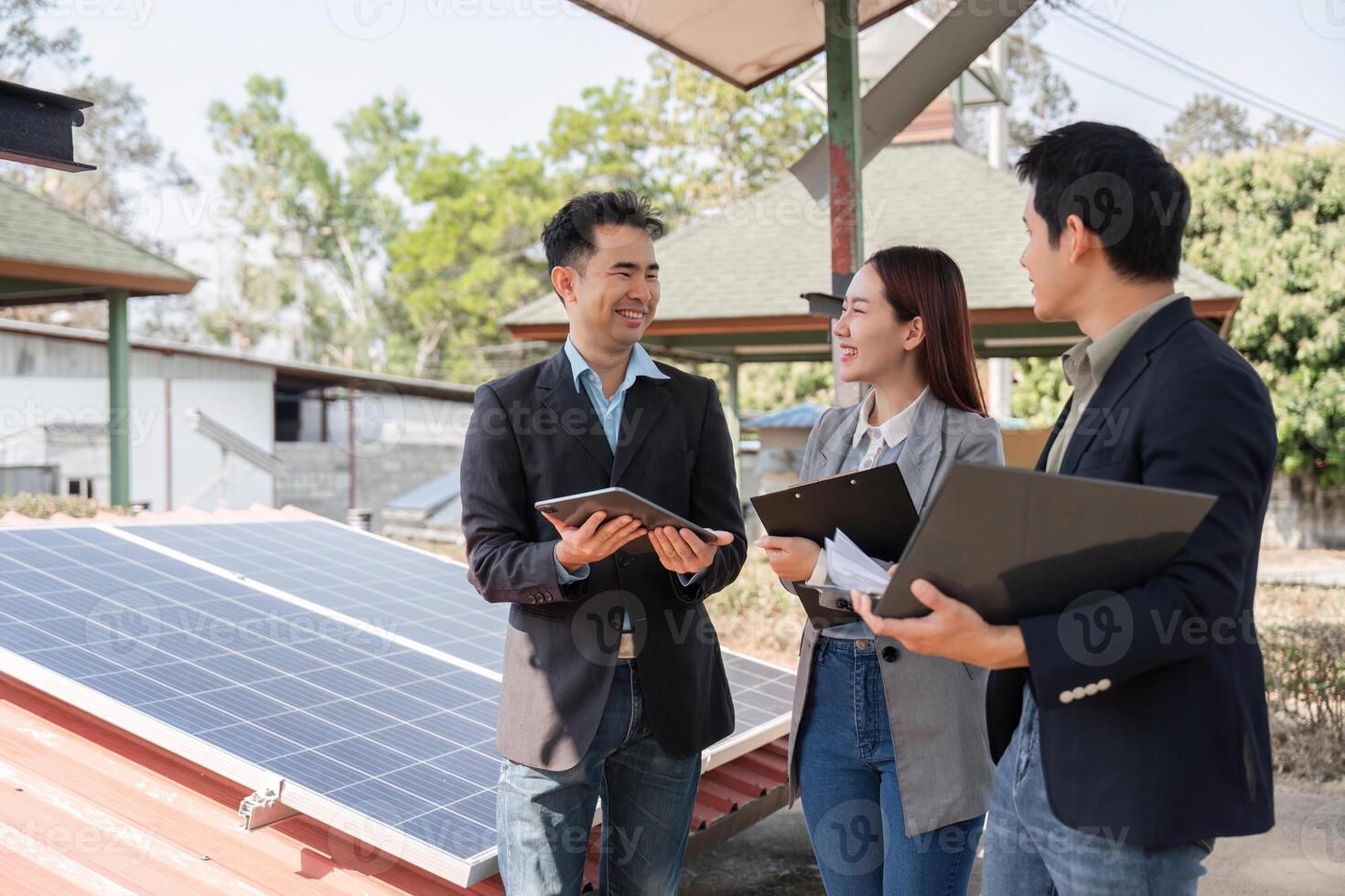 Collaborative energy solutions. Professionals engaged in discussion under solar panels. photo