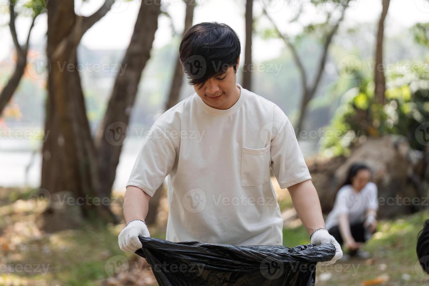 Volunteer cleaning up the environment, collecting trash in a park photo