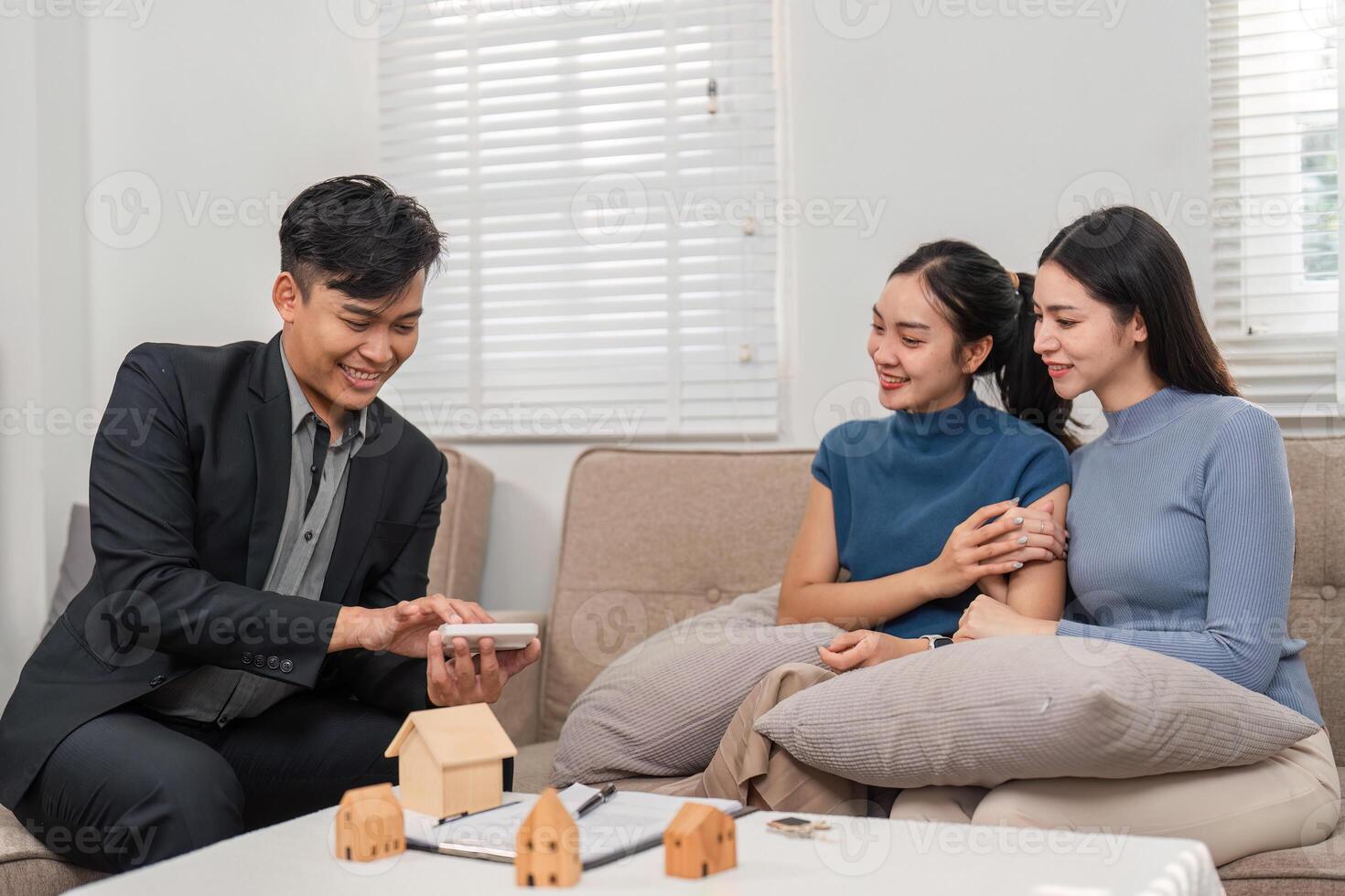 Technology in real estate. A real estate agent shows property details on a digital device to two clients in a lively setting. photo
