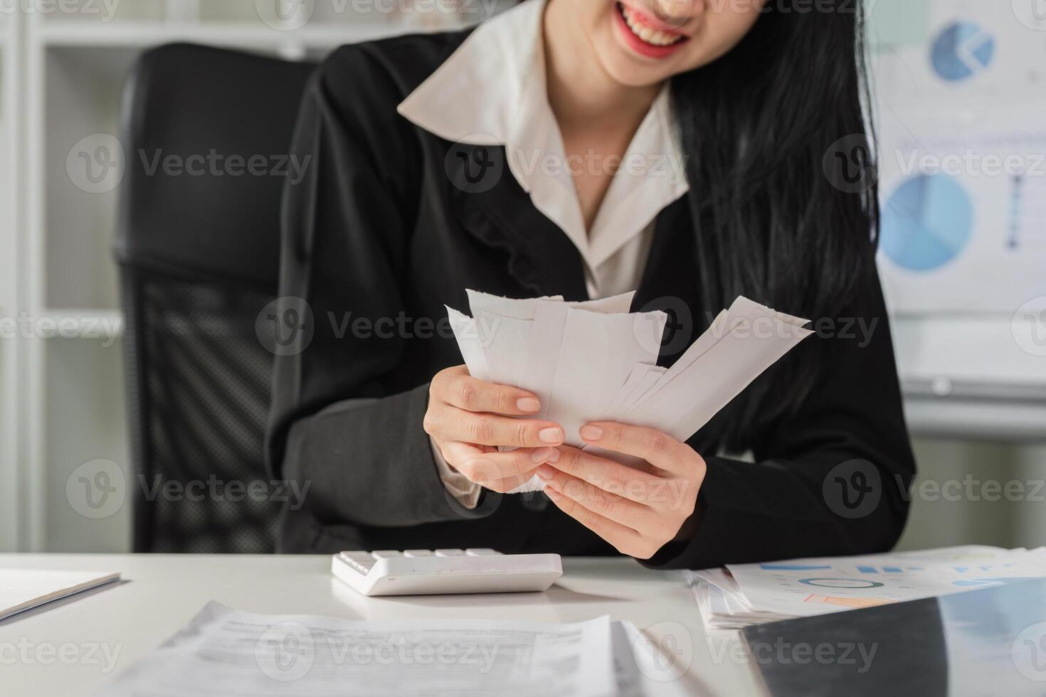 Financial organization and management. Woman smiling while sorting through tax documents. photo