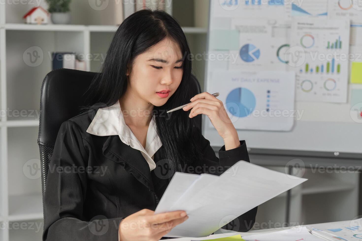 Business analysis and decision-making. Professional woman reviewing financial reports in an office setting. photo