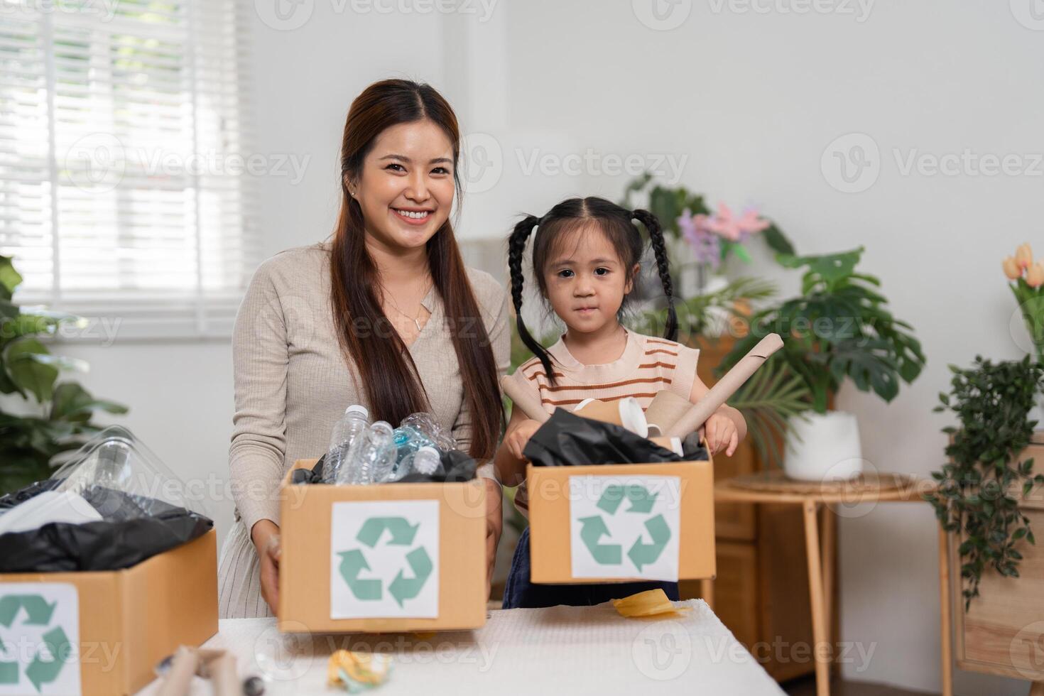 Eco-Friendly Practices and Family Togetherness. A mother smiling with her daughter while sorting recyclable materials into labeled boxes. photo