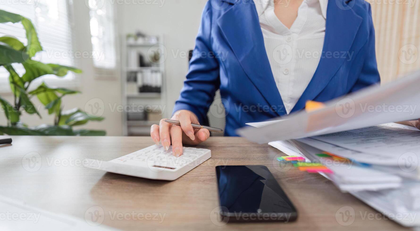Business and finance. Professional woman calculating taxes with documents and calculator in office setting. photo