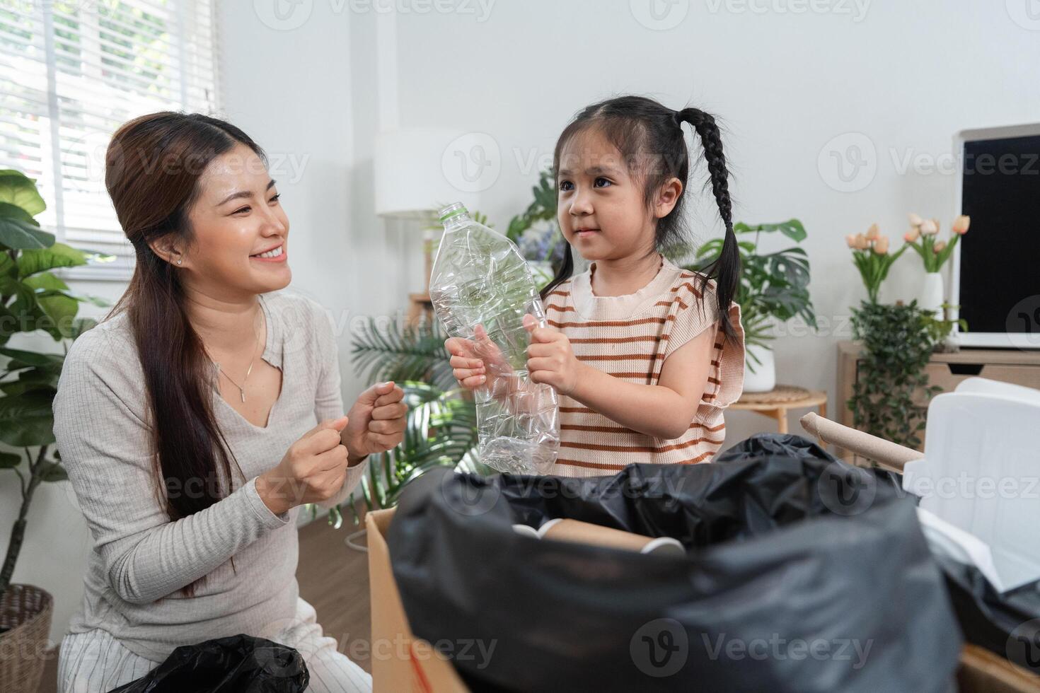 Joyful Recycling and Family Values. A mother and child excitedly sorting waste materials at home. photo