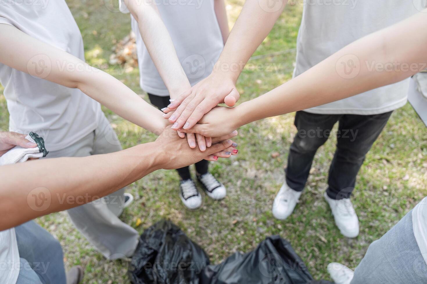 Teamwork in Action. Volunteers joining hands to symbolize unity in a clean-up project. photo