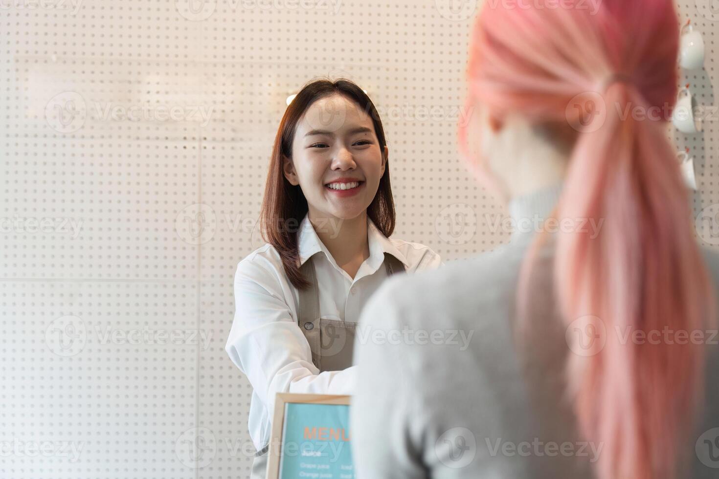 Customer Interaction and Coffee Experience. A smiling barista welcoming a customer with a friendly demeanor. photo